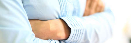 Woman stands with folded arms on her chest closeup.の写真素材