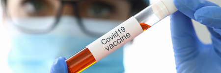Researcher holds flask with covid-19 vaccine closeupの写真素材