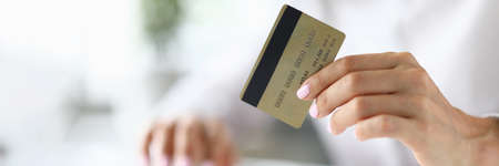 Female hand holds bank plastic card closeupの写真素材