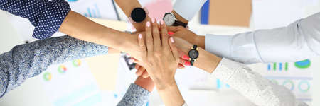Business people hold their hands over the table in lockの写真素材
