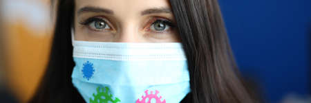 Woman in protective medical mask with coronavirus stickersの写真素材