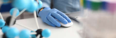 Workplace scientist with gloves working on laptopの写真素材