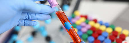 Researcher in gloves holds test tube with liquid.の写真素材