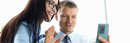 Work colleagues hold smartphone and communicate with their interlocutors online.の写真素材