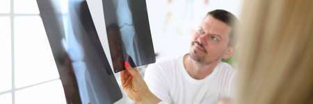 Male patient, together with doctor examines an X-ray.の写真素材
