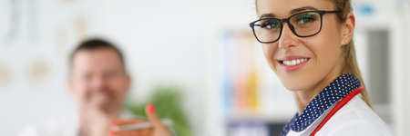 Female doctor smiling with colleague together closeupの写真素材