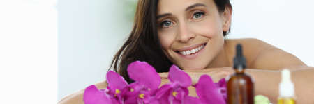 Woman lies and smiles in massage room closeupの写真素材