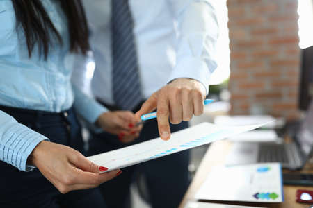 Man and woman colleagues examine document with schedule at workplace in company office close-upの写真素材
