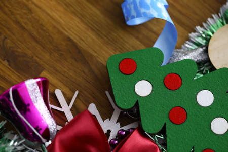 Christmas decorations, tinsel, small tree and decorations lie on wood closeupの写真素材