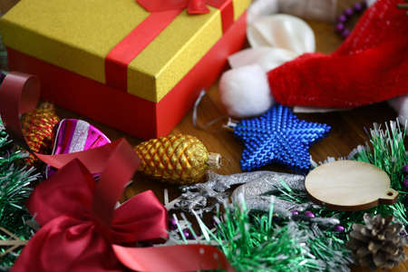 Christmas tree toys, red santa claus hat, tinsel and other decorations lie on table close-upの写真素材