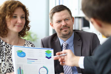 Man and woman at business meeting with partner examine document with diagram portraitの写真素材