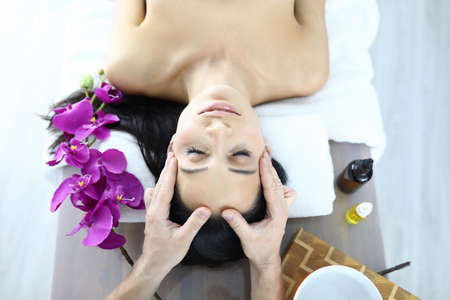 Portrait of woman who is being massaged closeupの写真素材