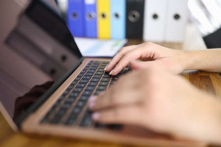 Female hands on laptop keyboard are typing text.の写真素材