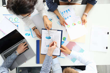 Colleagues at table discussing commercial performance in business