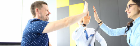 Man and woman in office holding hands in greetingの写真素材