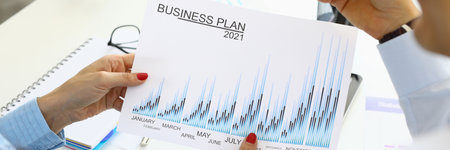 Female hands hold 2021 business plan at the table in office colleague is sitting next to itの写真素材