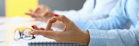 Female and male hands are connected in yoga fingers for meditation at table in office.の写真素材