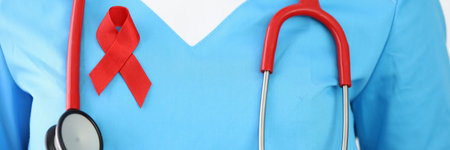 Doctor with stethoscope and red ribbon on his chest.の写真素材
