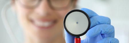 Smiling doctor holding stethoscope in his hand.の写真素材