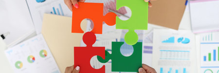 Employees in office hold colorful puzzles and put them togetherの写真素材