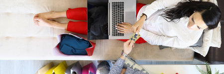 Man at home gives woman a plastic credit card for shopping on Internet.の写真素材