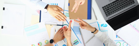Employees in office at table play with paper scissors.の写真素材