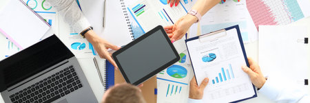 Business people stand around table on which commercial graphics tablet laptop lieの写真素材