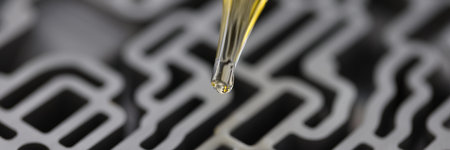 Dispenser pipette drips yellow liquid into automatic gearbox in chemical laboratory closeupの写真素材