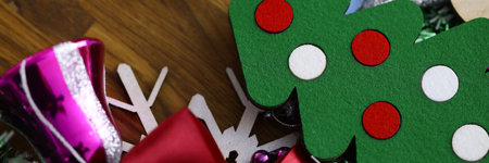 Christmas decorations, tinsel, small tree and decorations lie on wood closeupの写真素材