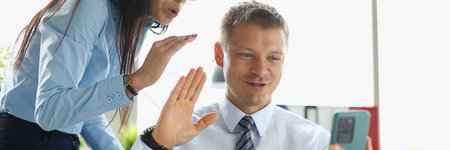 Businesswoman and businessman at work desk hold smartphone in their handsの写真素材