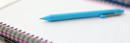 On table is notebook and blue penの写真素材