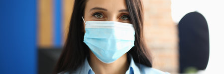 Portrait of businesswoman in protective medical mask in officeの写真素材