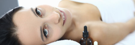 Portrait of smiling woman on massage table in spa center.の写真素材