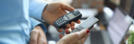 Two business people partners hol button vintage phone nokia 8800 and 3310 in hands closeupのeditorial素材