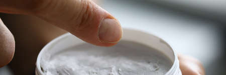 In hands of jar of white cream closeupの写真素材