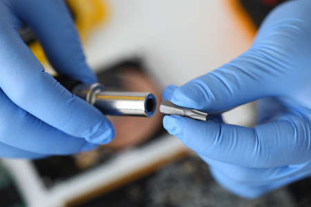 Master repairman inserting metal head into screwdriver closeupの写真素材