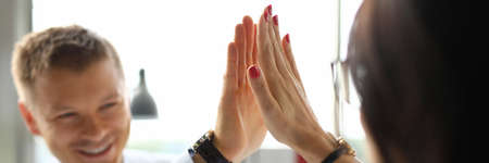 Businessman and businesswoman smile and give each friend five.の写真素材