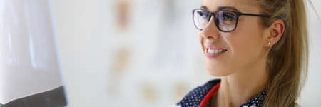 Woman doctor in glasses looks at examination results.の写真素材