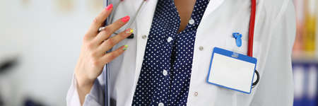 Woman doctor with stethoscope holds clipboard in her hands.の写真素材