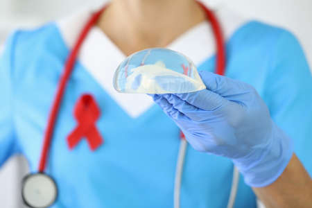 Doctor holds breast implant in his hand.の写真素材
