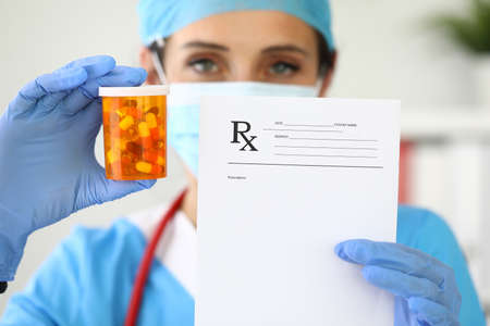 Female doctor is holding jar and medical prescriptionの写真素材