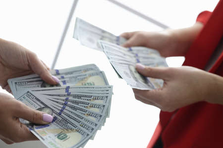 Two people are holding American banknotes in their hands.の写真素材