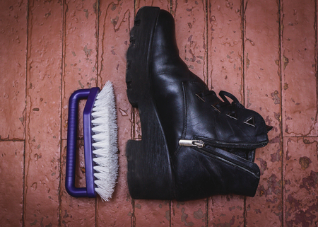 Shoe Polishing with female legs in black boots isolated over whiteの写真素材