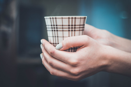 hands holding hot cup of coffee or tea in morning relaxの写真素材