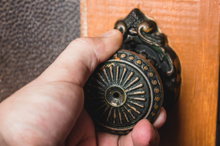 Hand opening the wooden door homeの写真素材