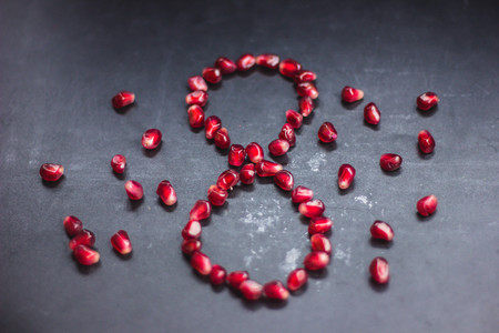 Juicy garnet, with a pleasant shade of red is on a glossy black background, which perfectly combines with the red color of the fruit. Muffled light creates a pleasant atmosphere.の写真素材