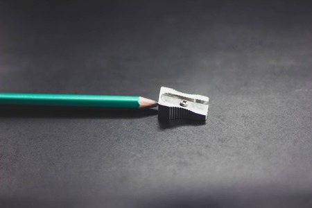 Pencil with sharpening shavings on black background woodの写真素材