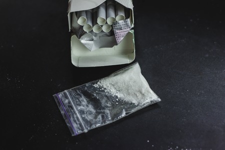 cigarettes and cocaine black backgroundの写真素材
