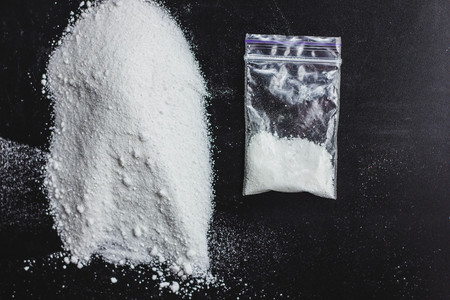 Cocaine drug powder pile on black backgroundの写真素材