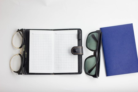Eye glasses, blank notepad, and mechanical pencil on the tableの写真素材